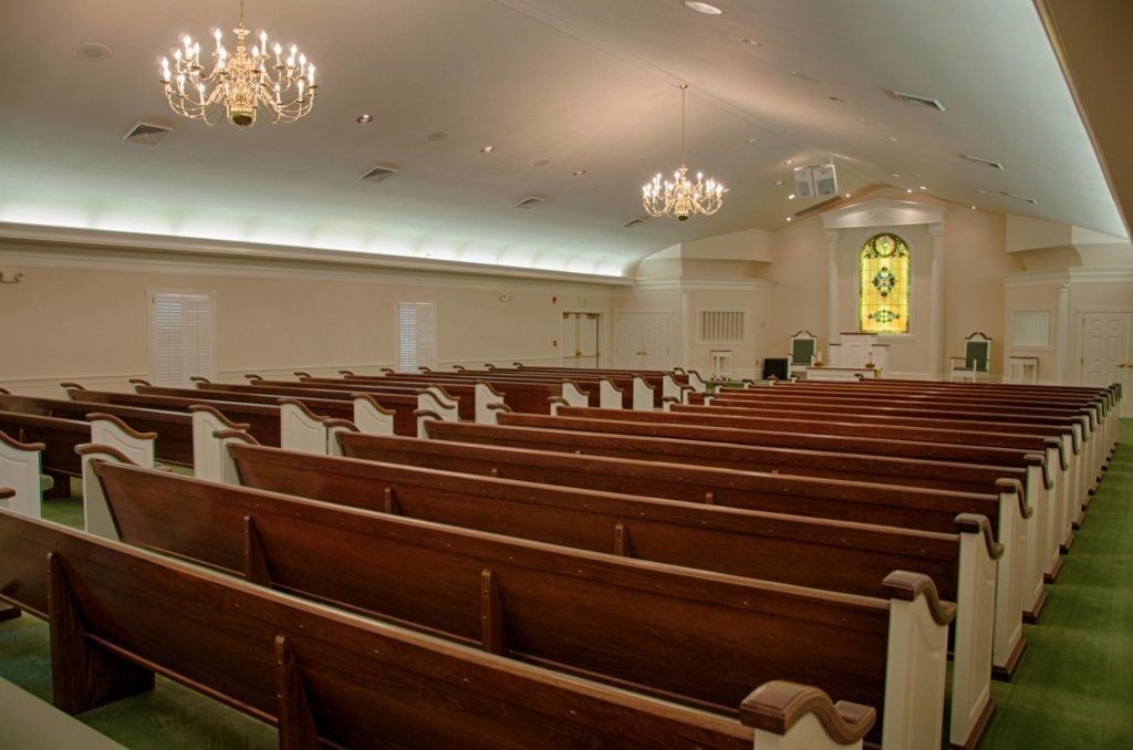 A silver coffin with red roses on top of it.