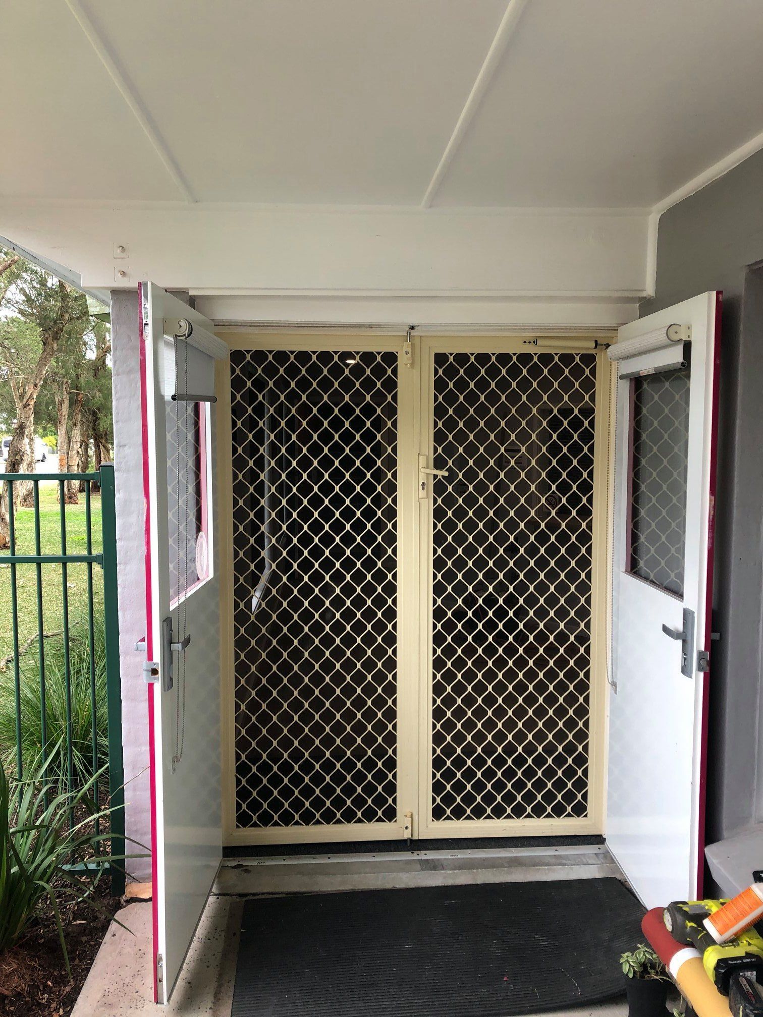 A door with a screen on it is open to a doorway.