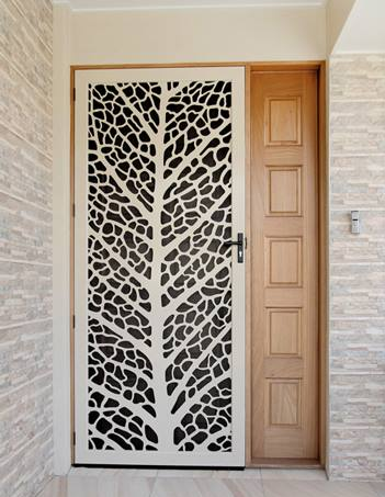 A white door with a tree design on it is next to a wooden door.