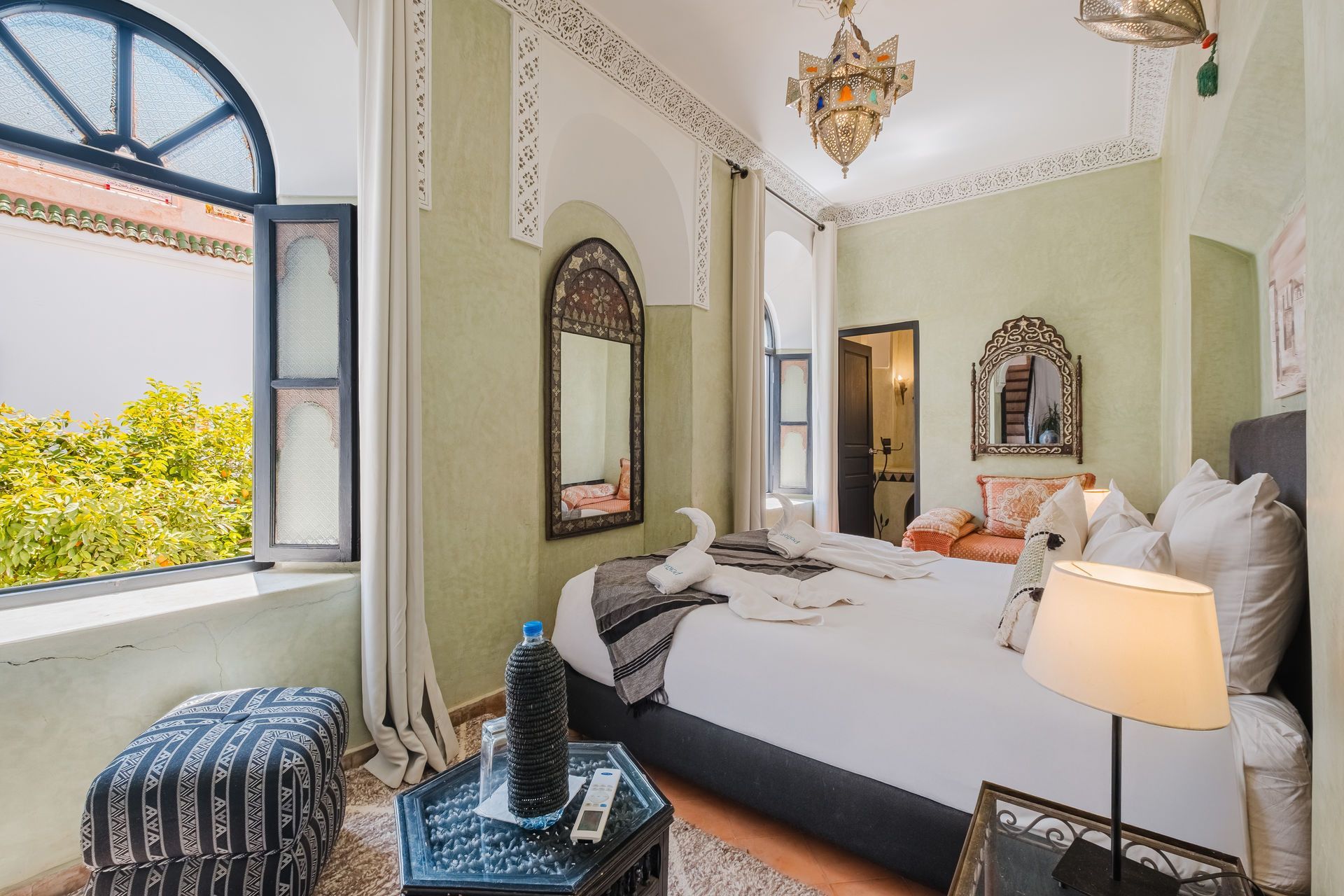 Bedroom with bed, window, and decorative details, in a Moroccan style.