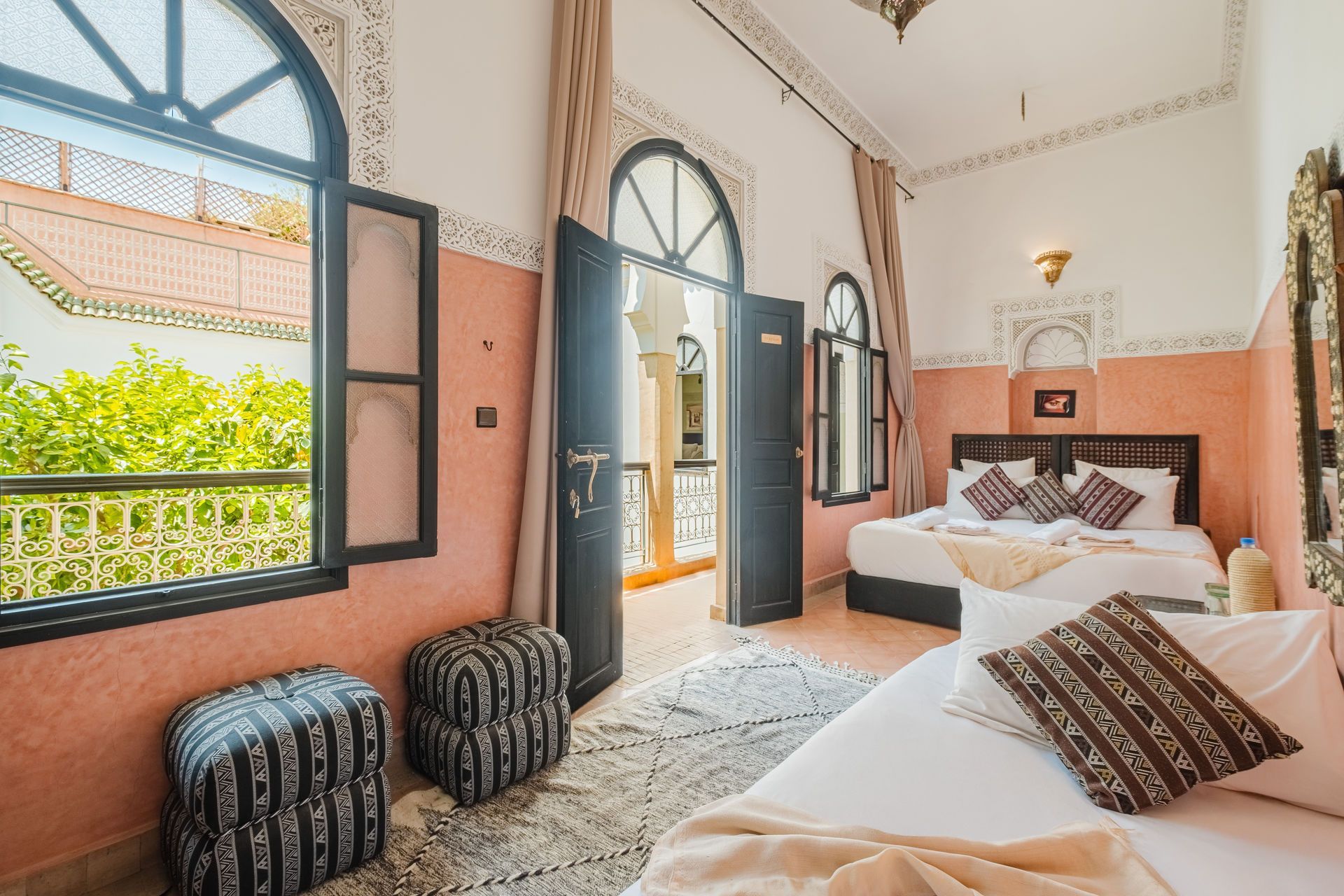 A Moroccan-style bedroom with a bed, sofa, and outdoor balcony view.