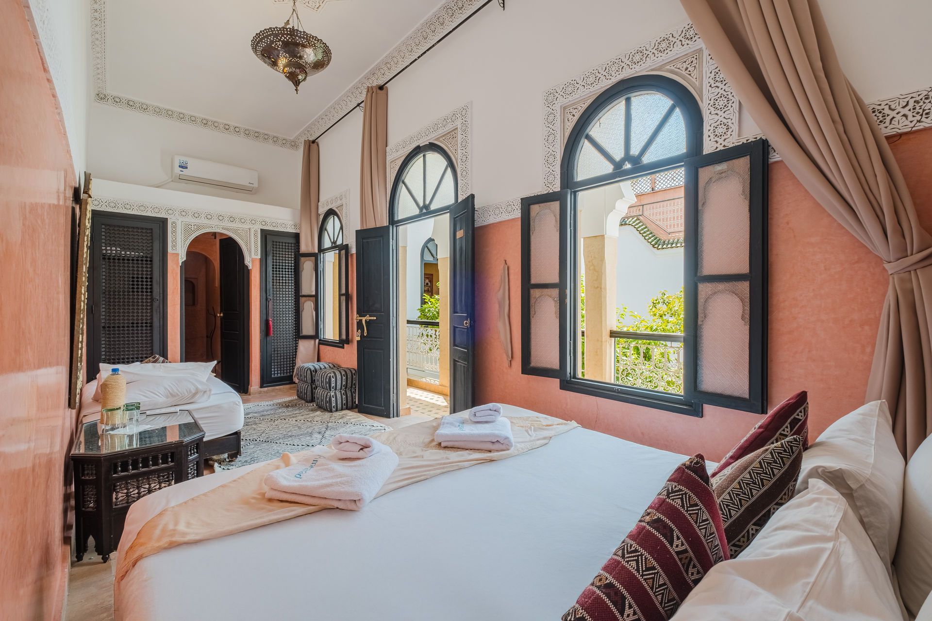Bedroom with bed, open windows, and decorative architectural elements.