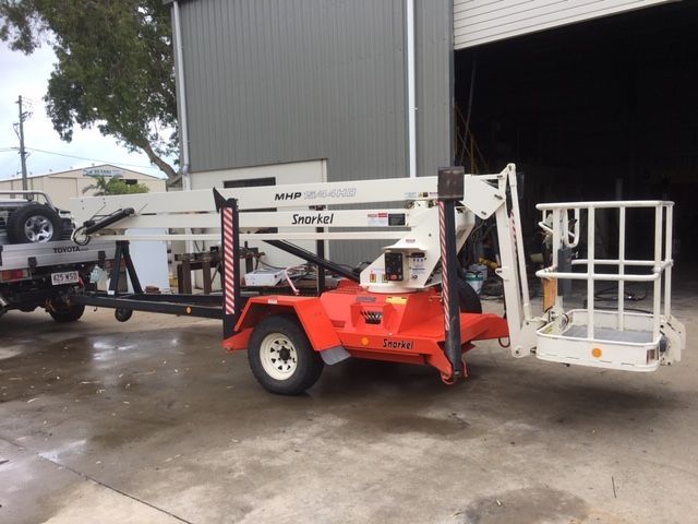A Man is Working on the Suspension of a Car in a Garage — Crane Maintenance Queensland in Moranbah,QLD