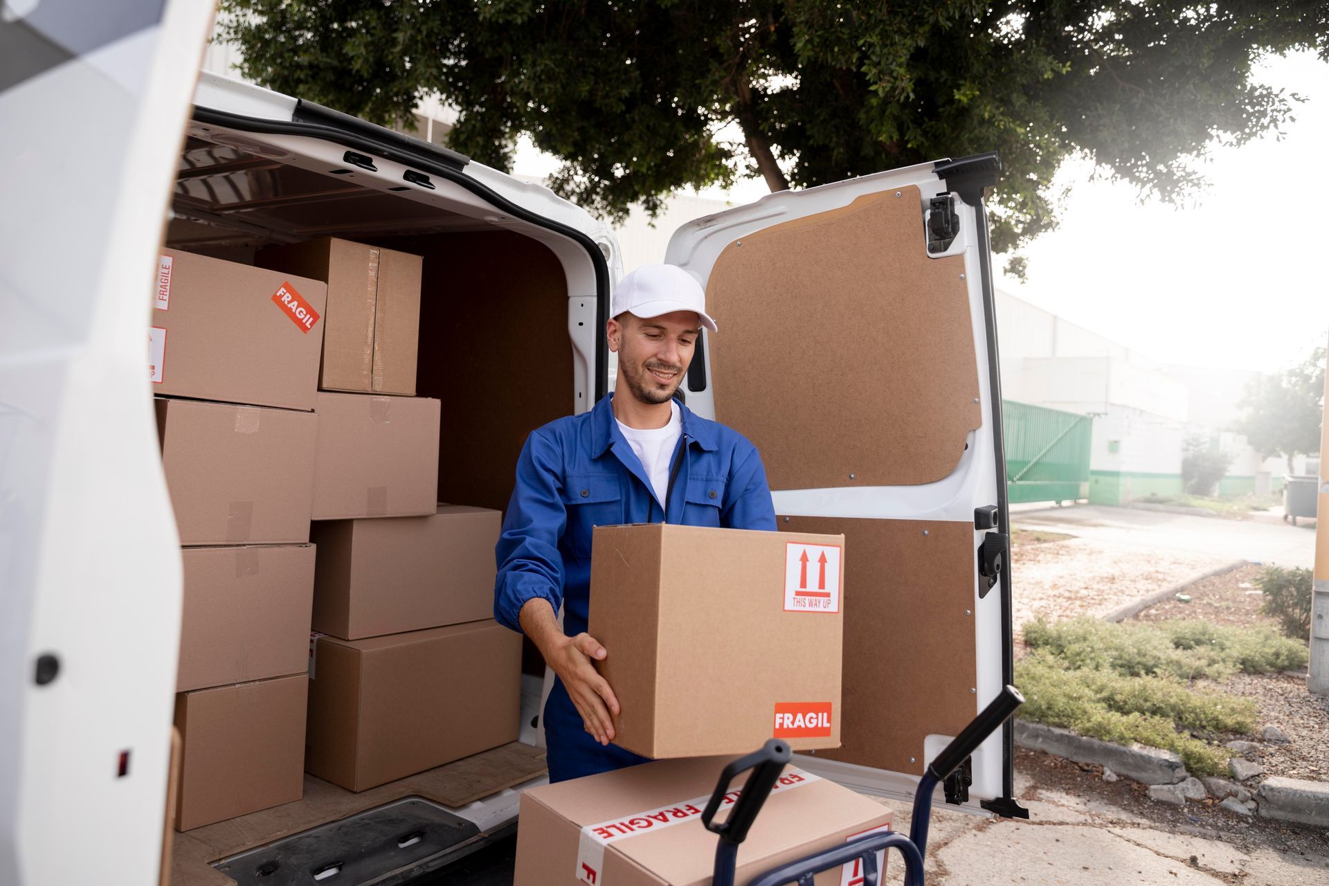 A delivery man is loading boxes into a van.