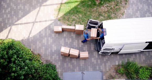 An aerial view of a delivery man loading boxes into a van.