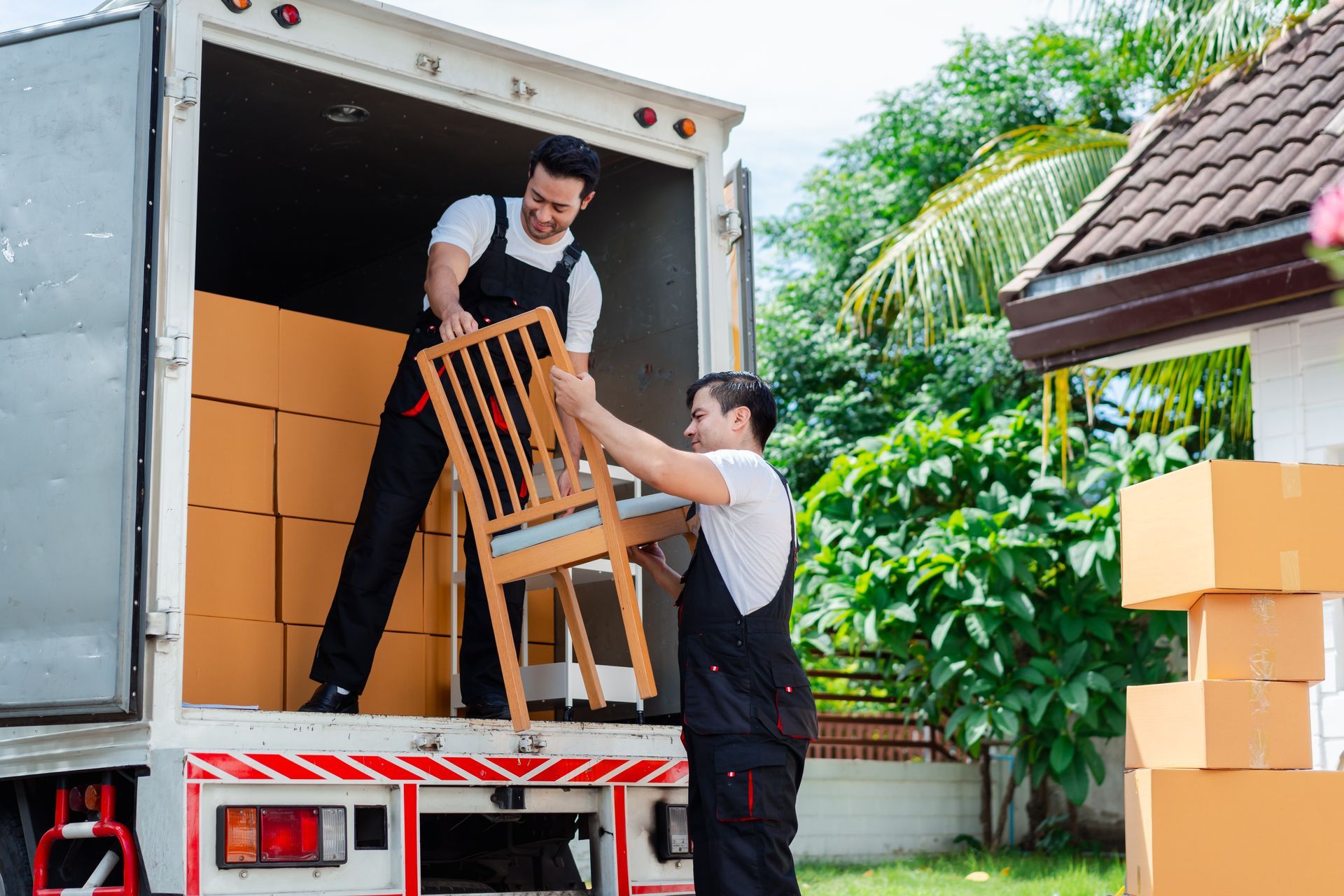 Two men are loading a chair into a moving truck.