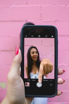 Una mujer se está tomando una foto con su teléfono celular.