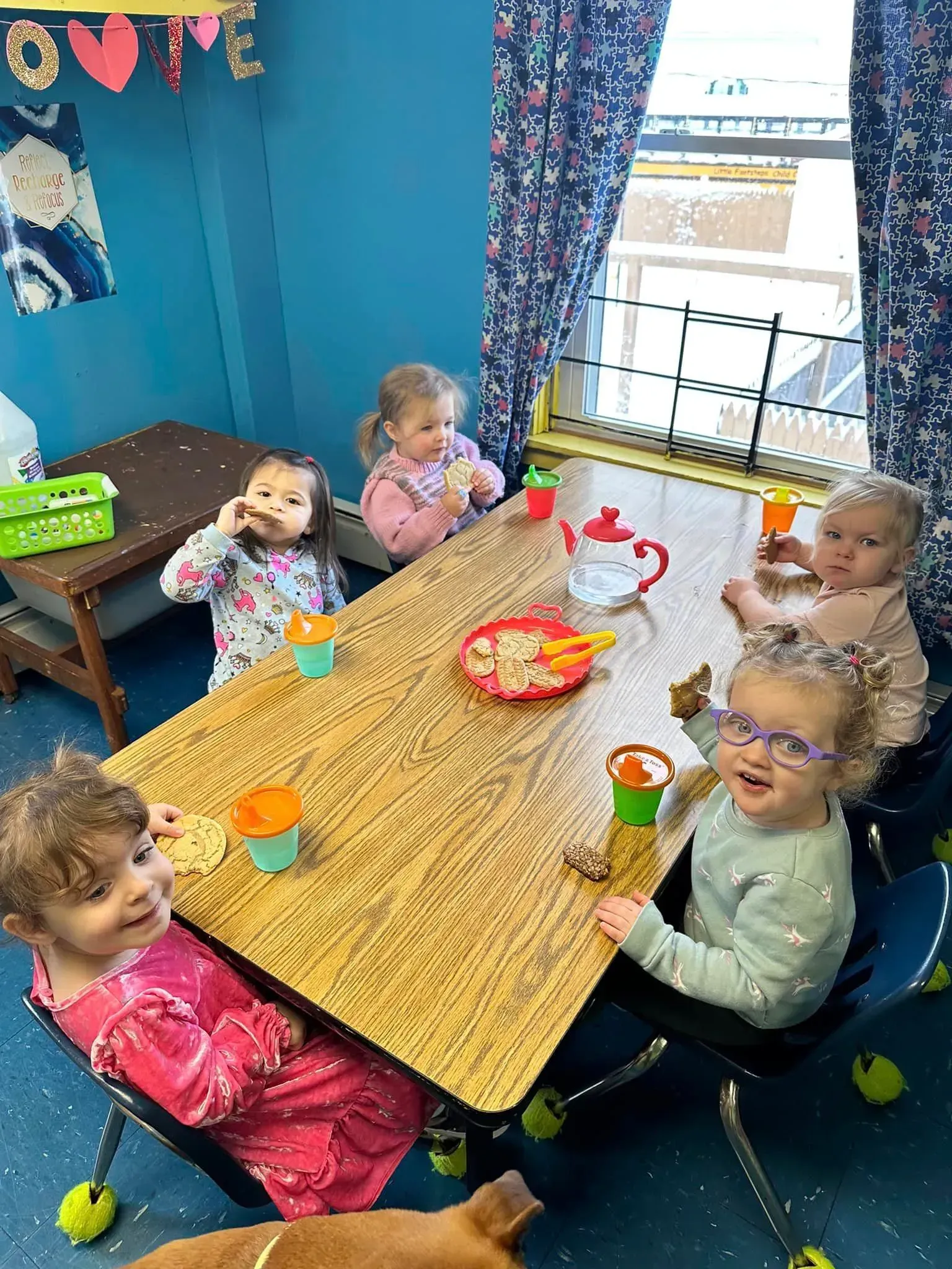 A group of children are sitting at a table eating food.