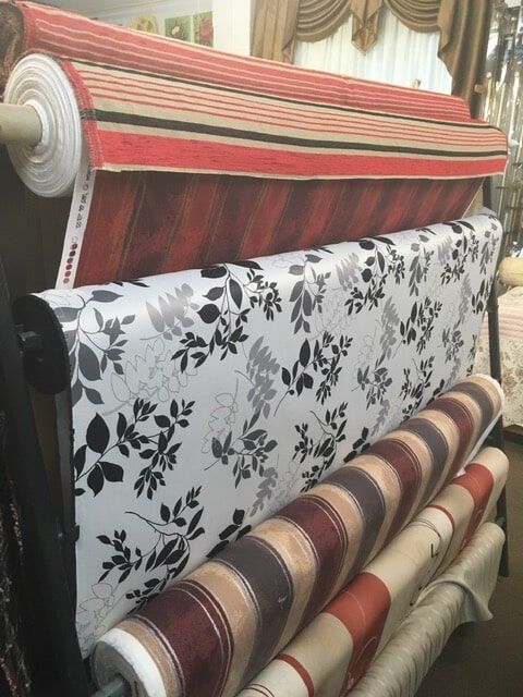 a roll of fabric is sitting on a rack in a store .