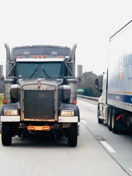 Older couple reviewing paperwork together at a table with a laptop in a bright home.