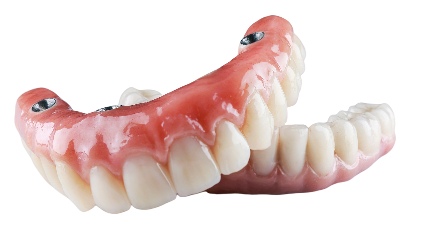 A close up of a denture on a white background.