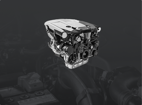 A silver and black internal combustion car engine displayed against a dark, moody background.