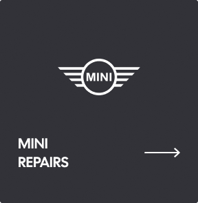 A dark grey sign with the white Mini logo, the text 
