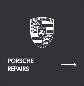 A black sign with the white Porsche crest, the text 