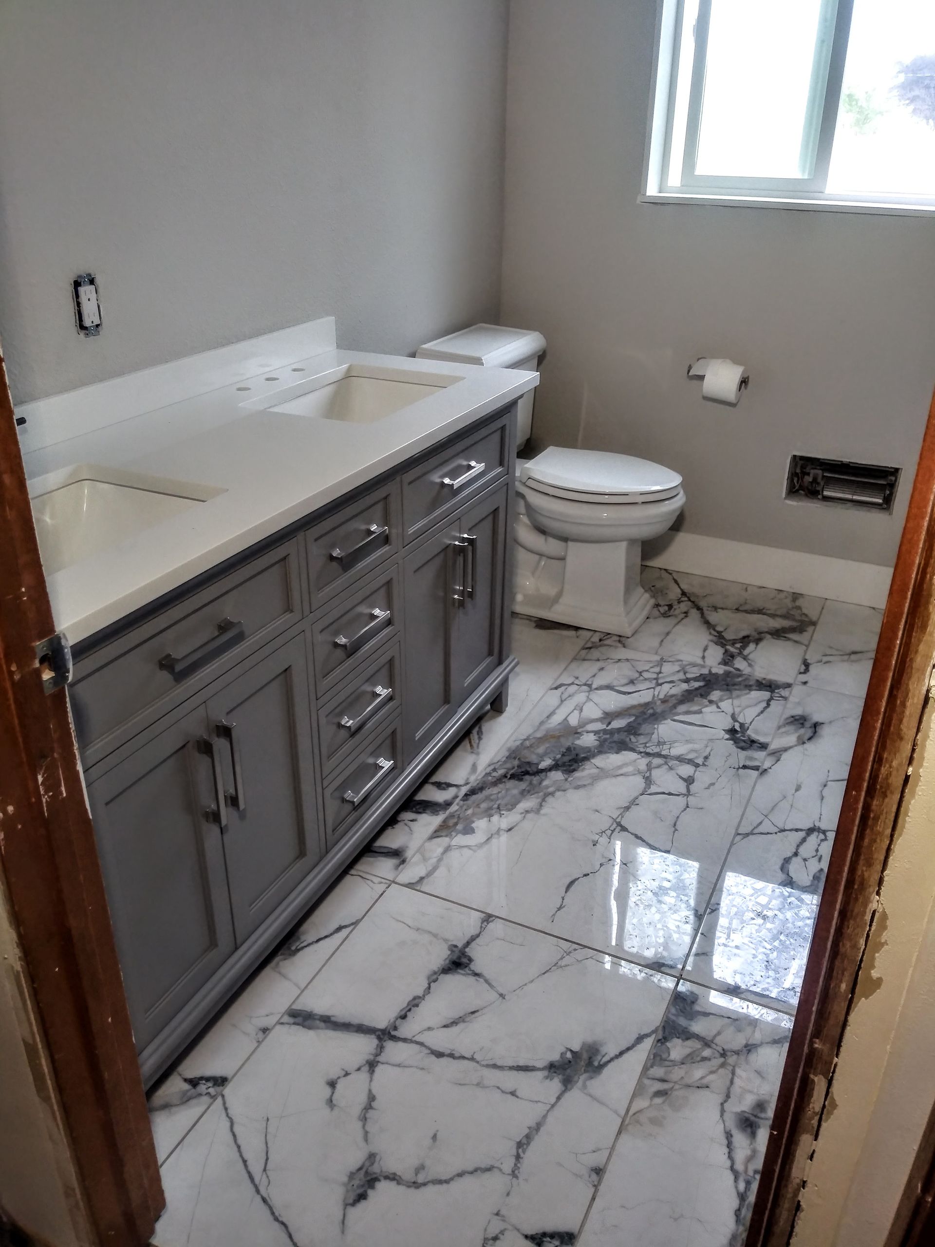 a bathroom with a sink , toilet , and marble floor .