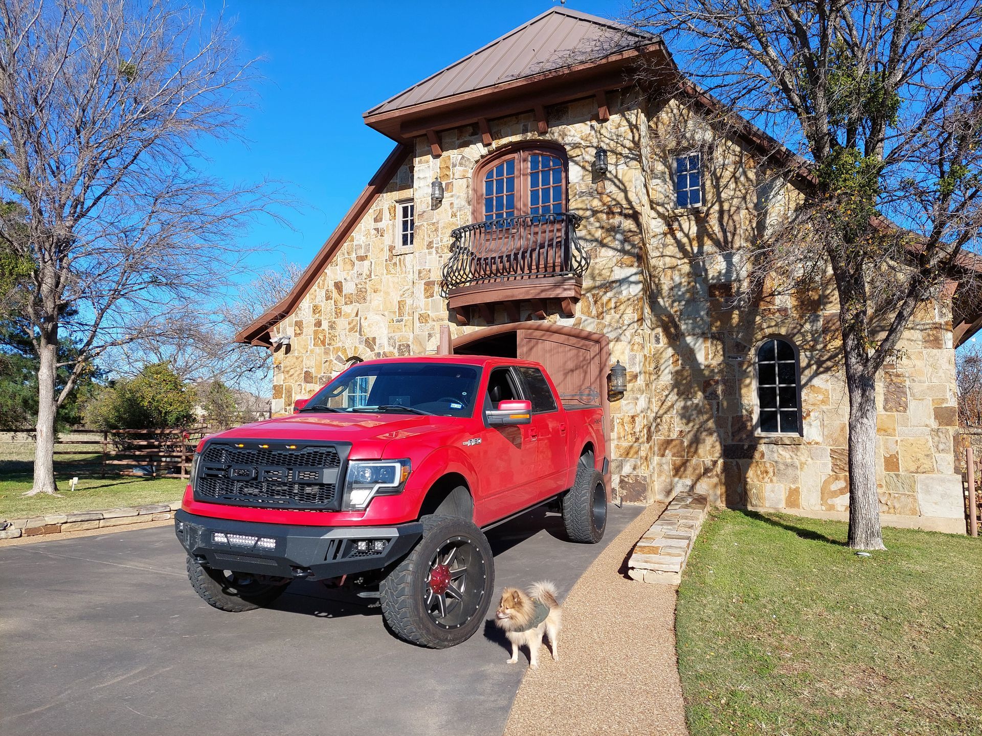 a red truck is parked in front of a stone building .