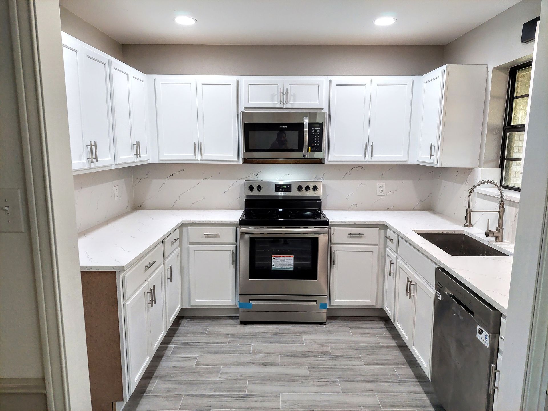a bathroom with marble walls and a walk in shower with a glass door .