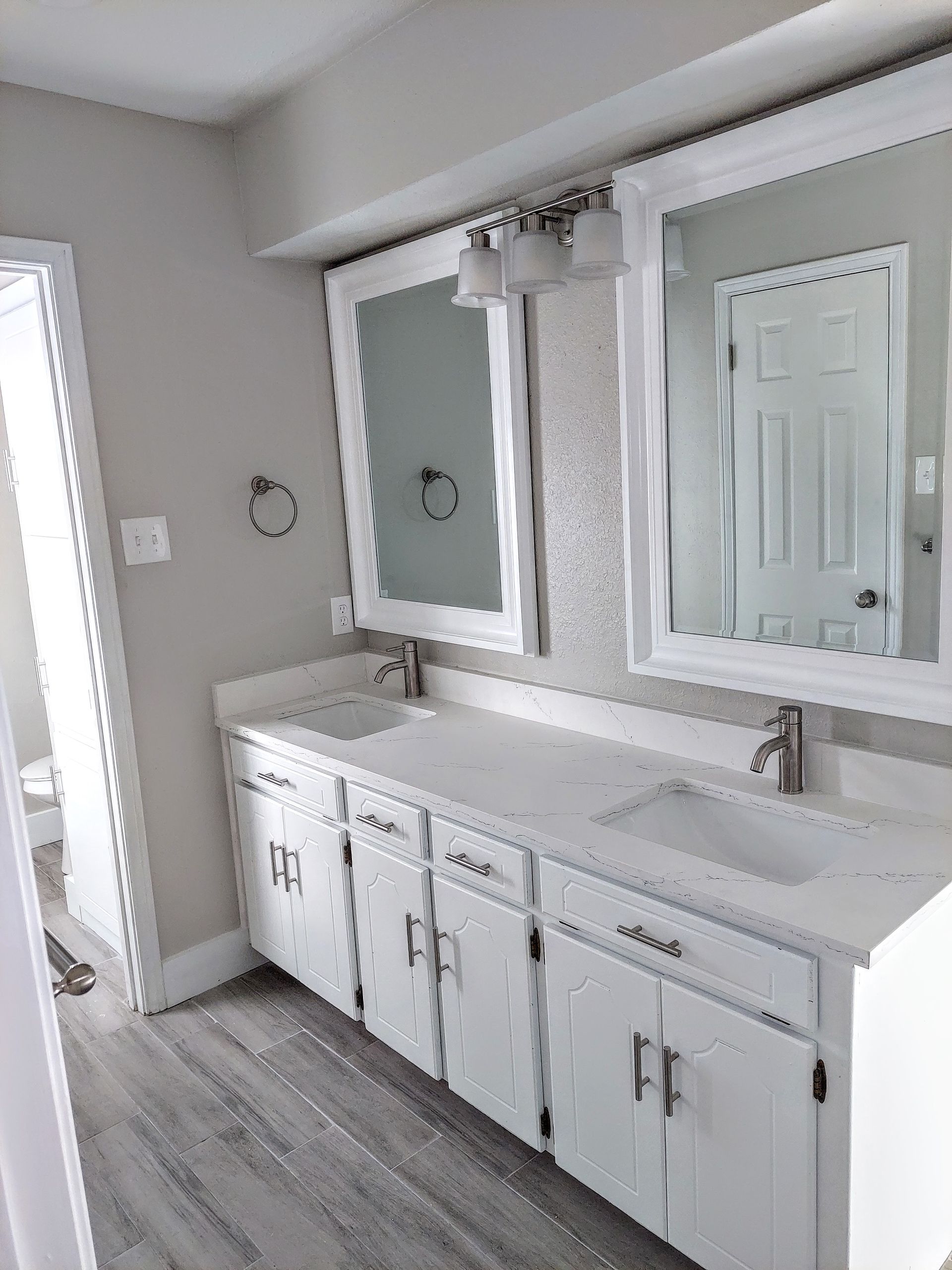 a bathroom with two sinks and two mirrors .