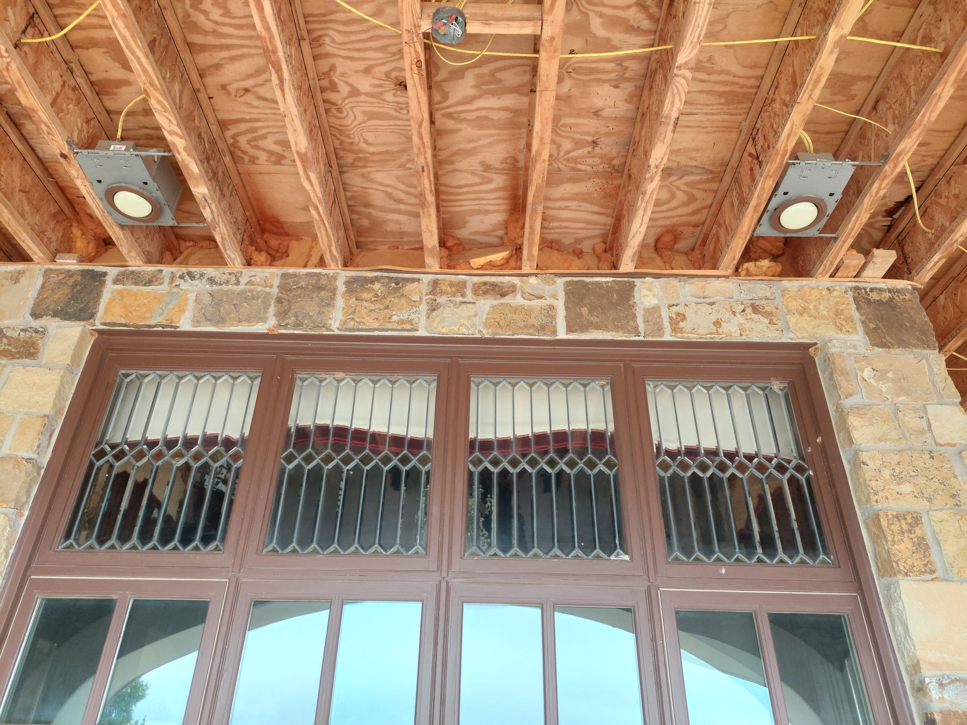 a building under construction with a large window and a wooden ceiling .