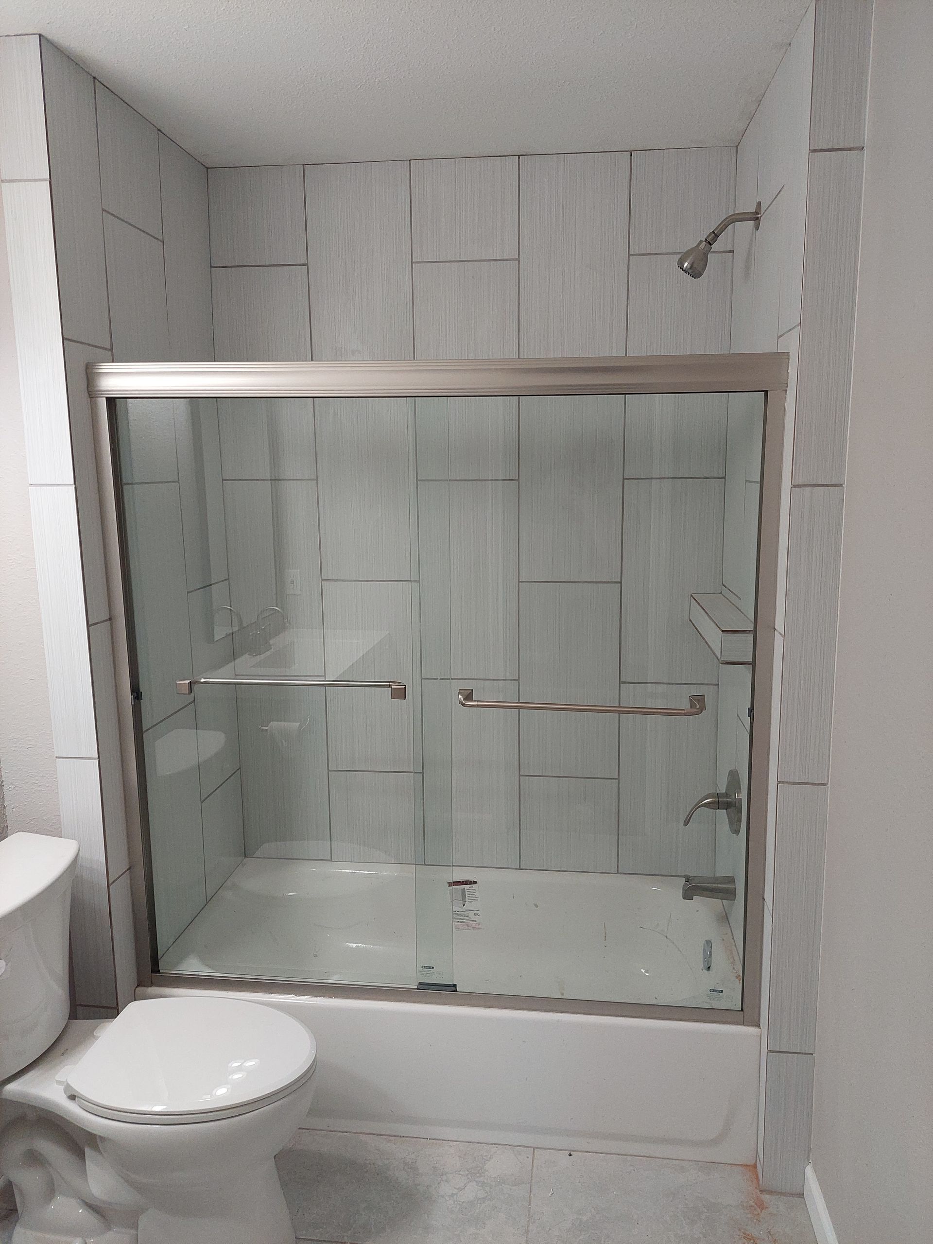 a bathroom with a sliding glass shower door and a toilet