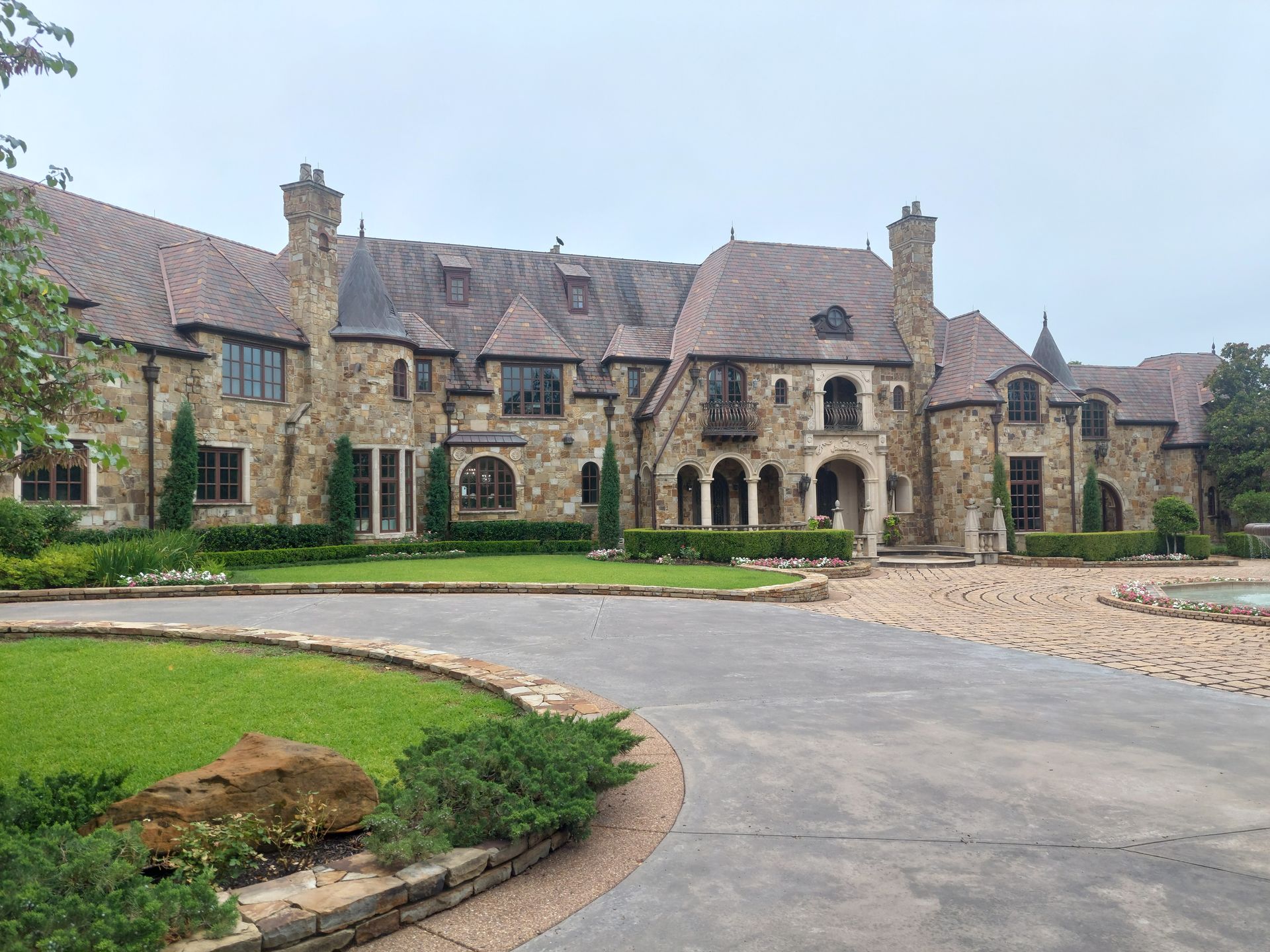 a large stone house with a driveway leading to it .