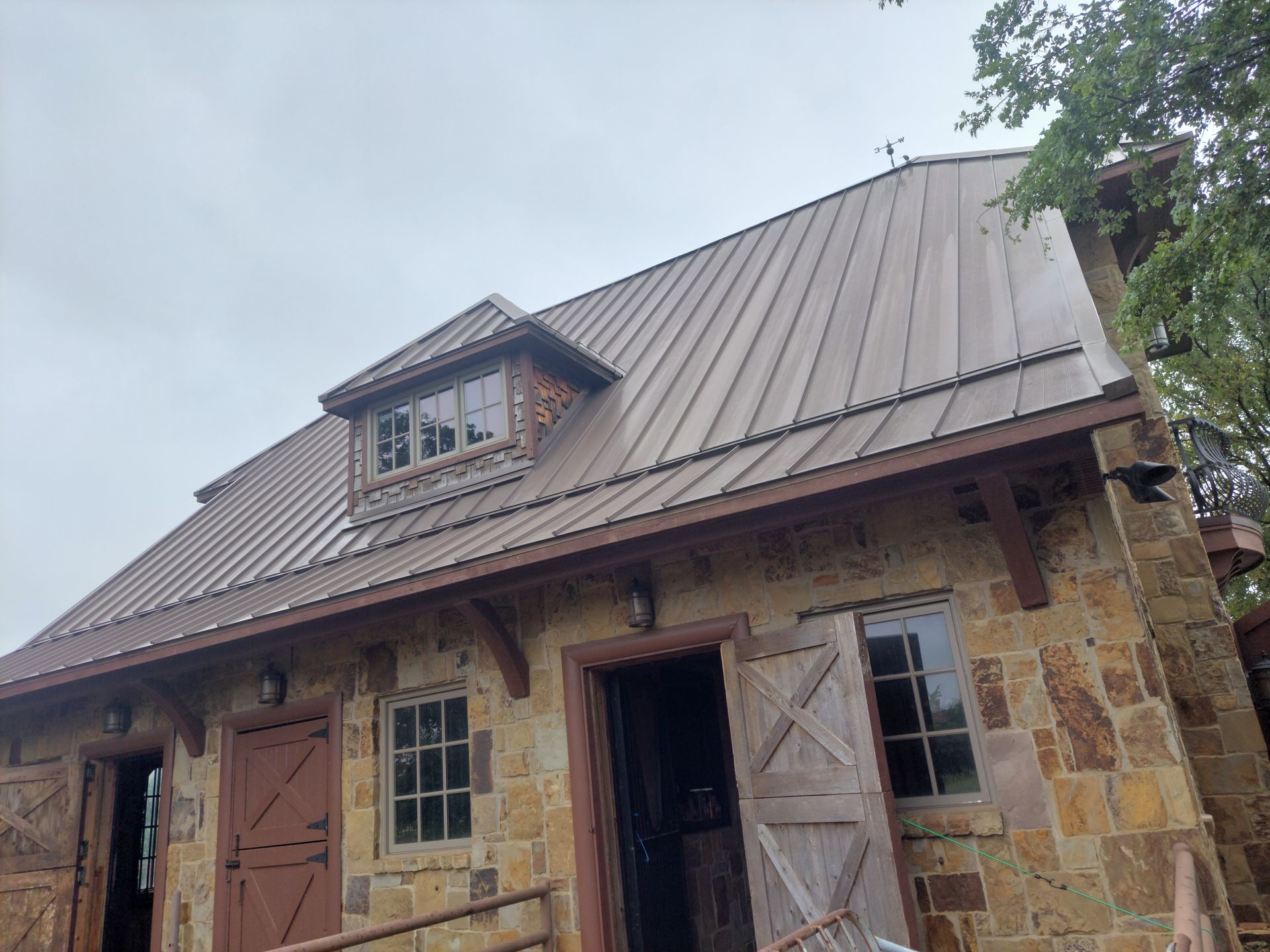 a stone building with a metal roof and windows .