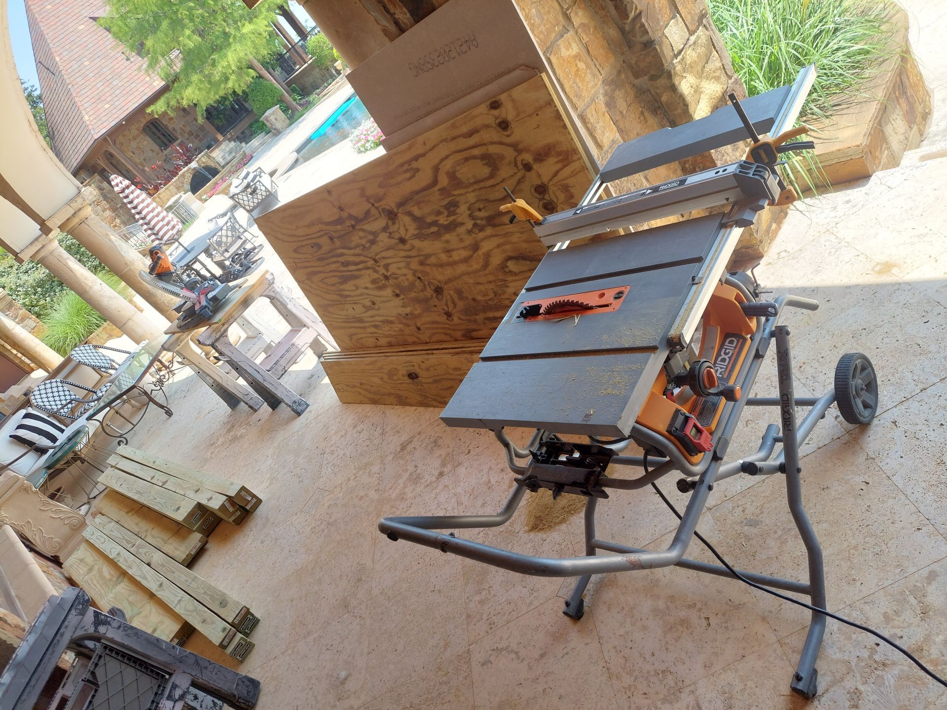 a table saw is sitting on a patio next to a pool .