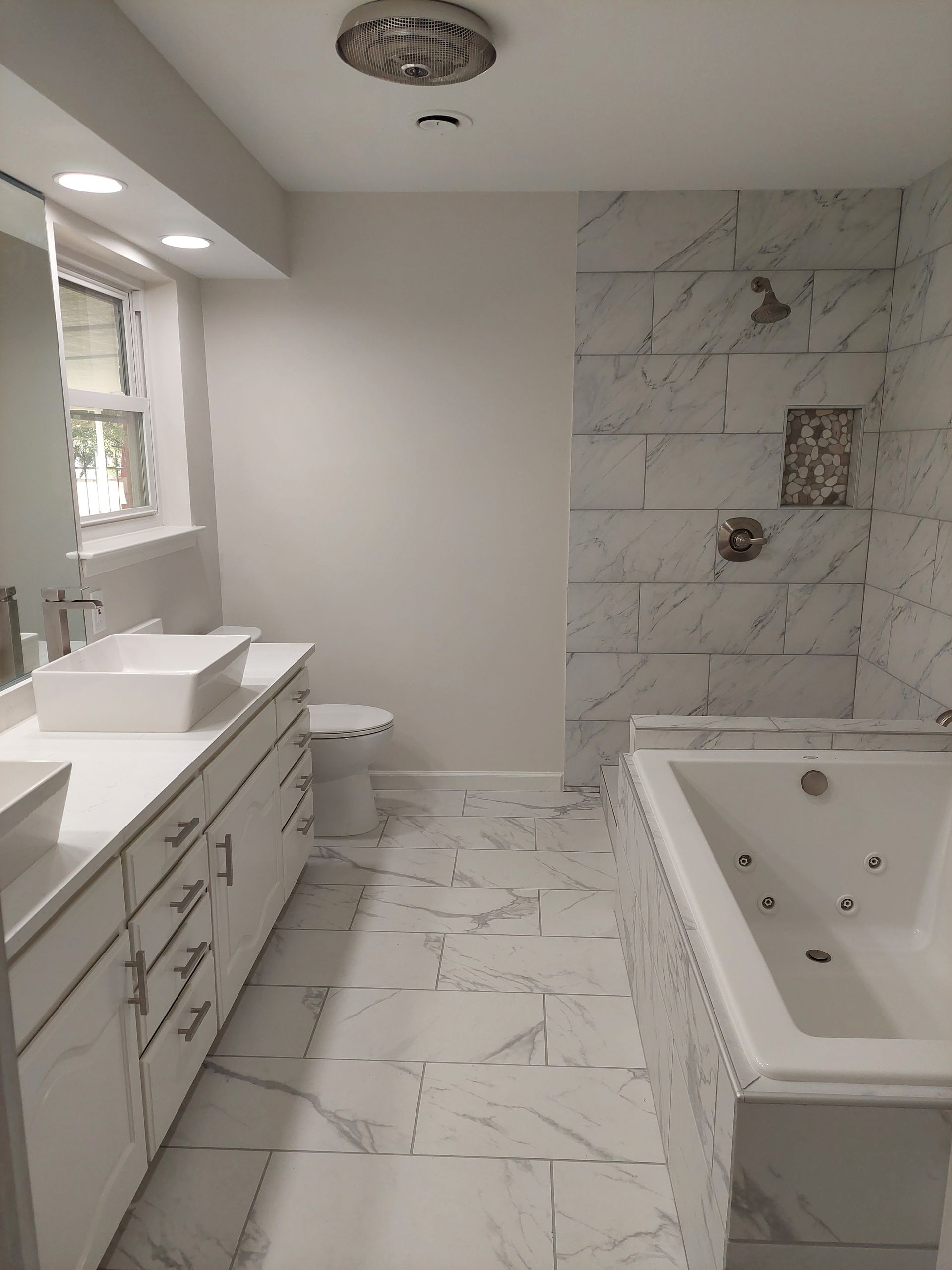 a bathroom with two sinks , a toilet , and a bathtub .