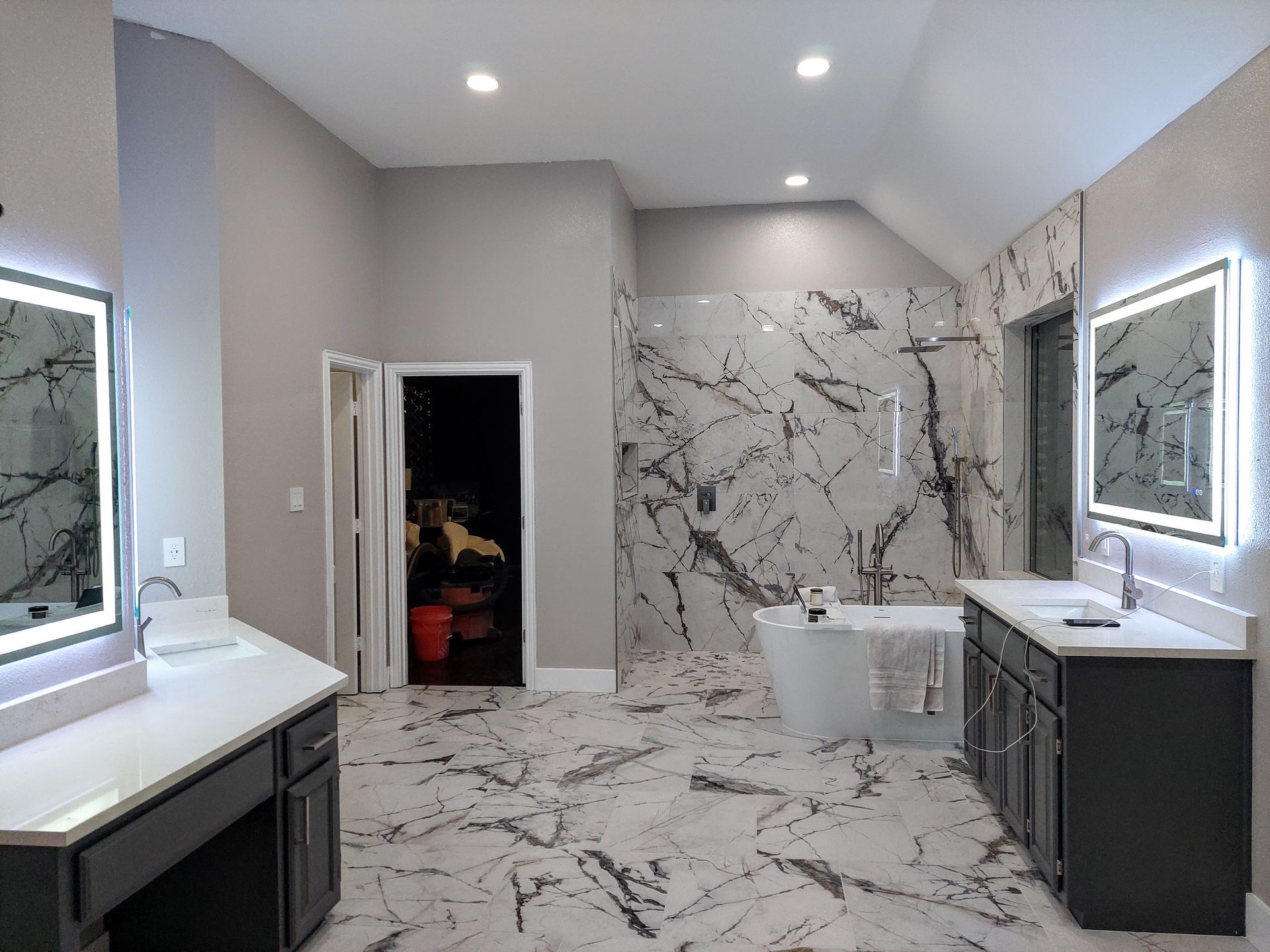 a bathroom with a bathtub , sinks , mirrors and a walk in shower .