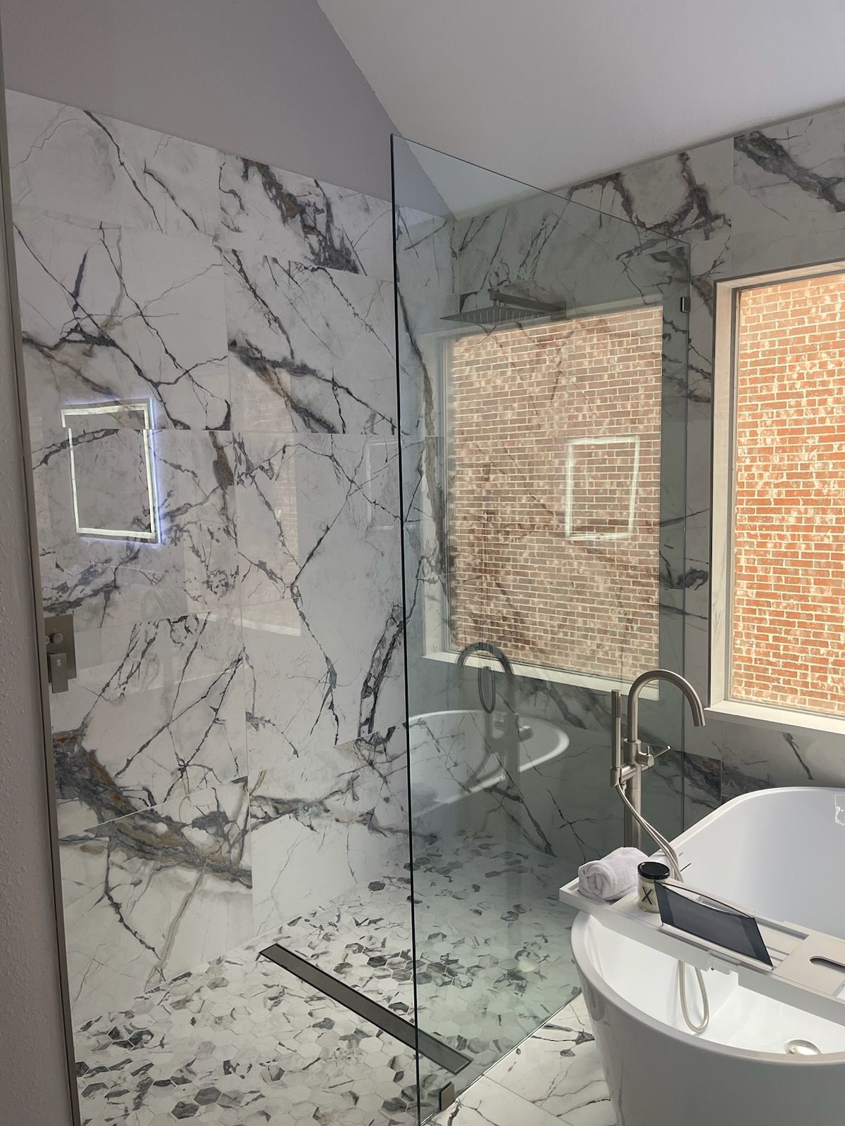 a bathroom with a tub , sink , shower and mirror .