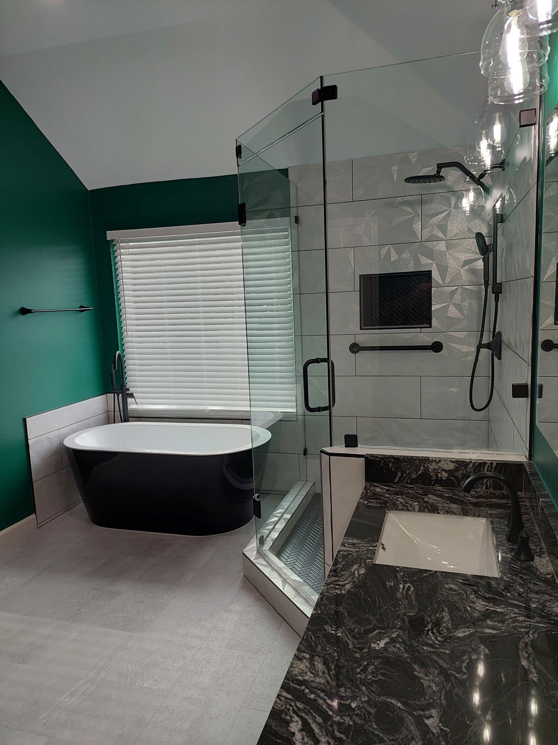 a bathroom with a tub , sink , shower and window .