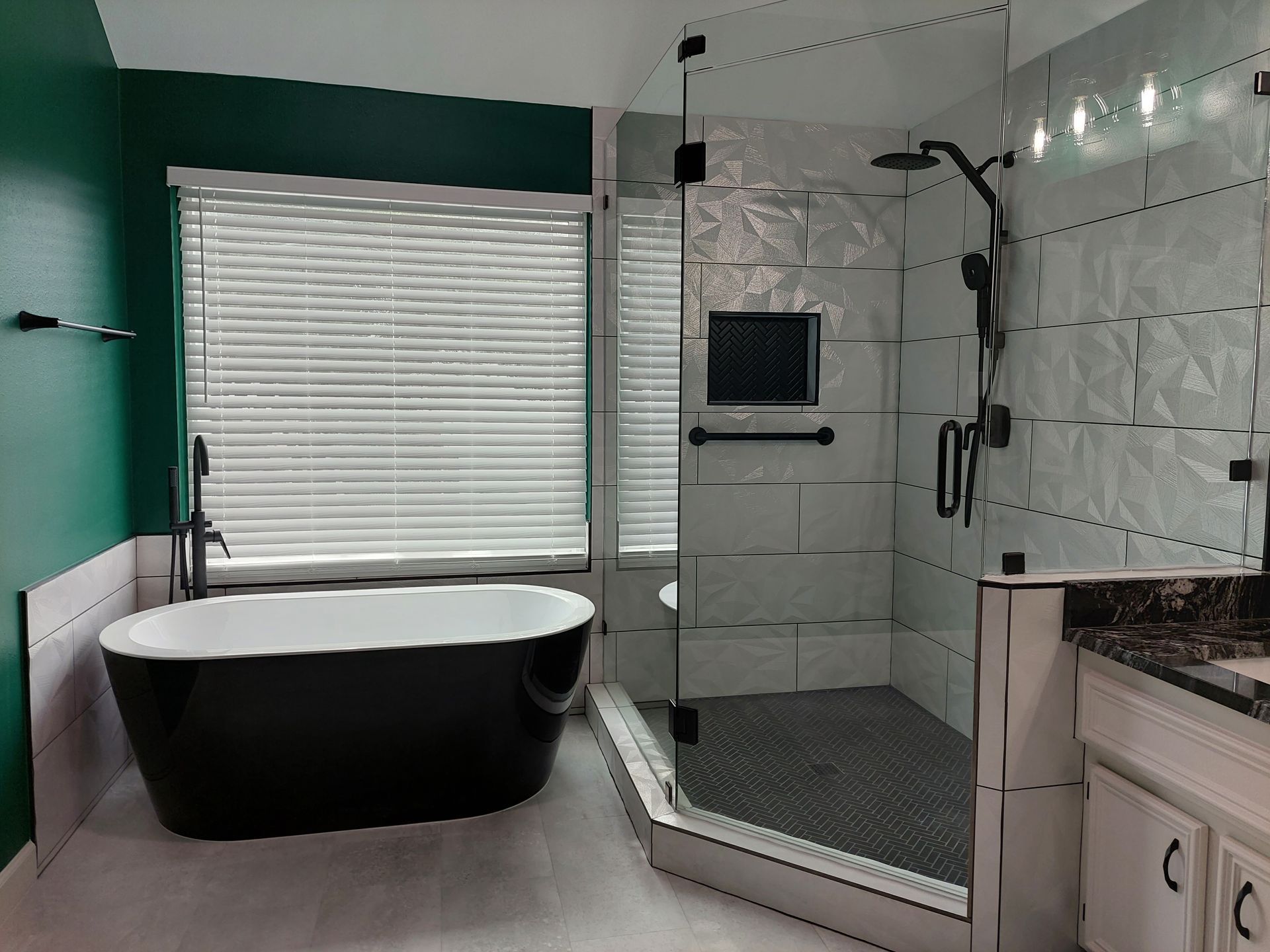 a bathroom with a black tub and a walk in shower .