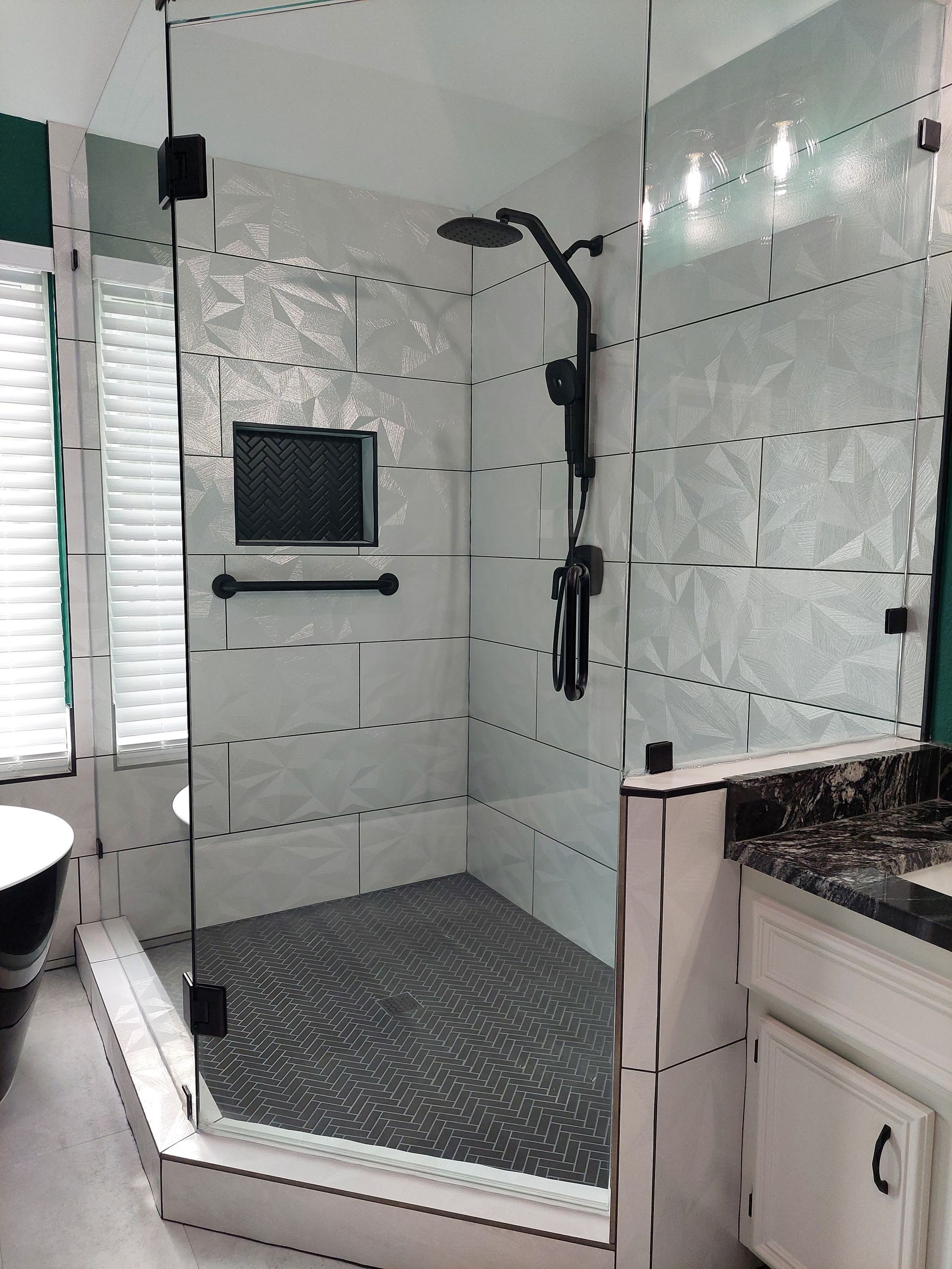 a bathroom with a walk in shower and a sink .