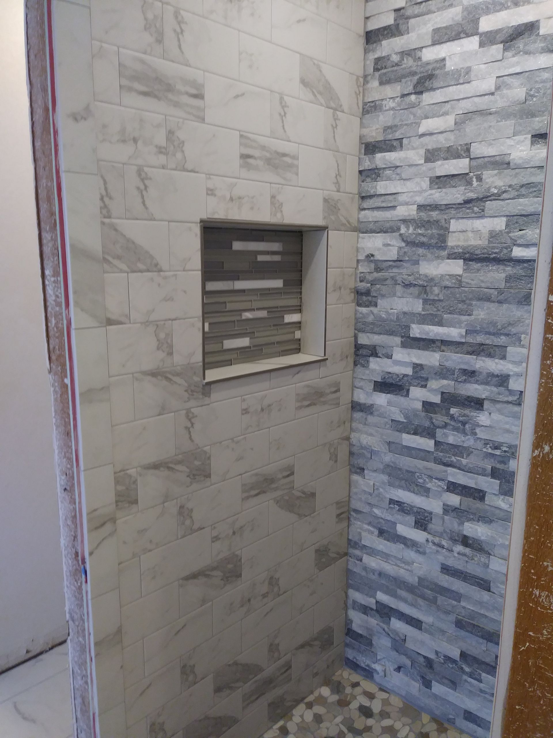 a bathroom with a brick wall and a niche in the wall .