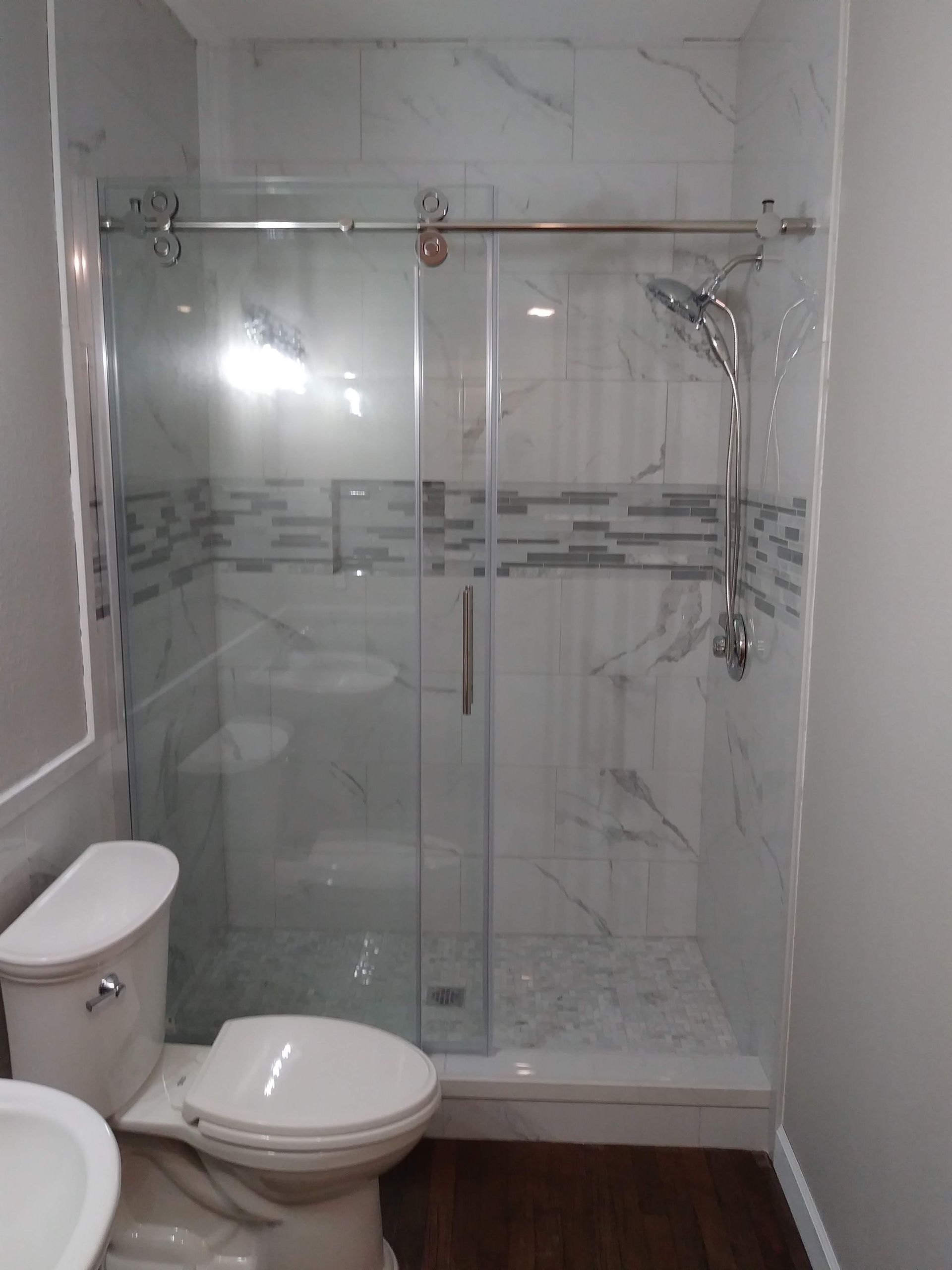 a bathroom with a toilet , sink and shower .