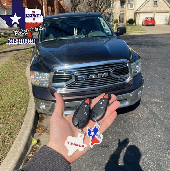 Licensed locksmith showing the accomplished job, holding duplicate remote keys for Dodge ram in Austin, Texas. 
