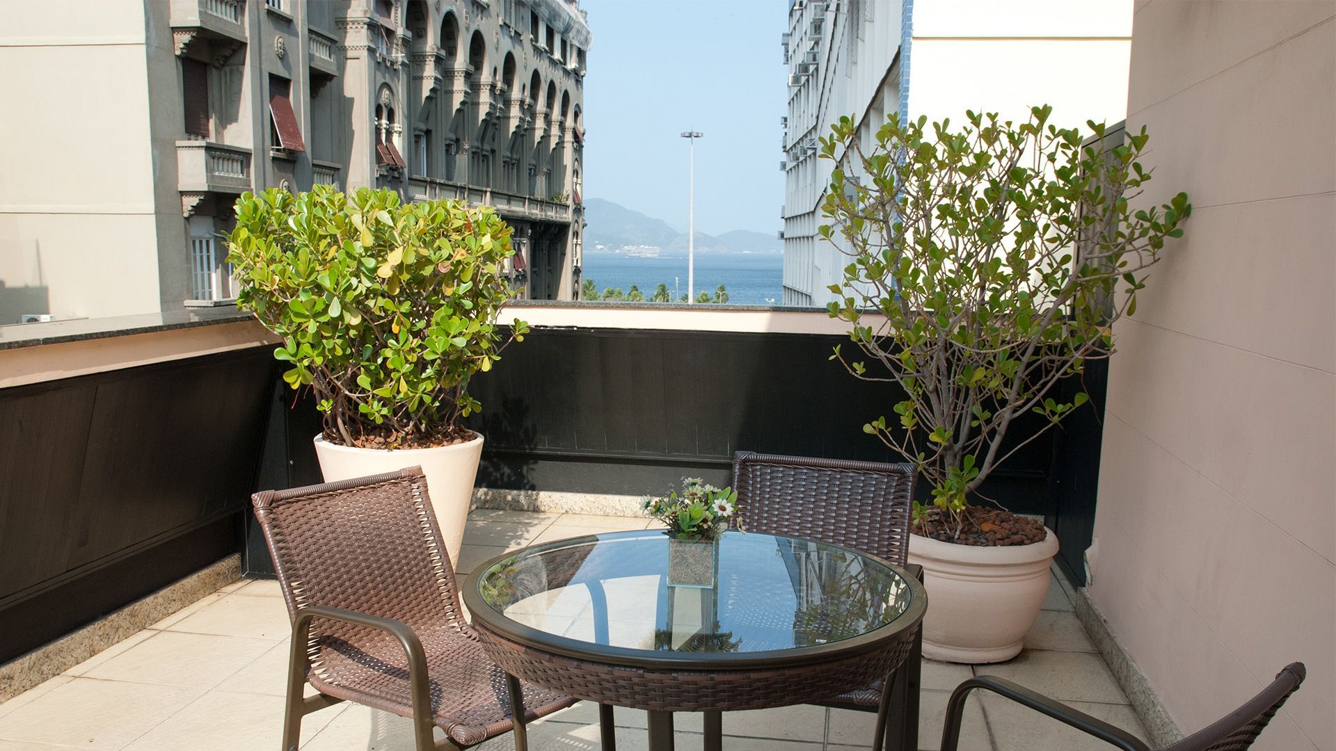 Uma mesa e cadeiras em uma varanda com vista para o oceano