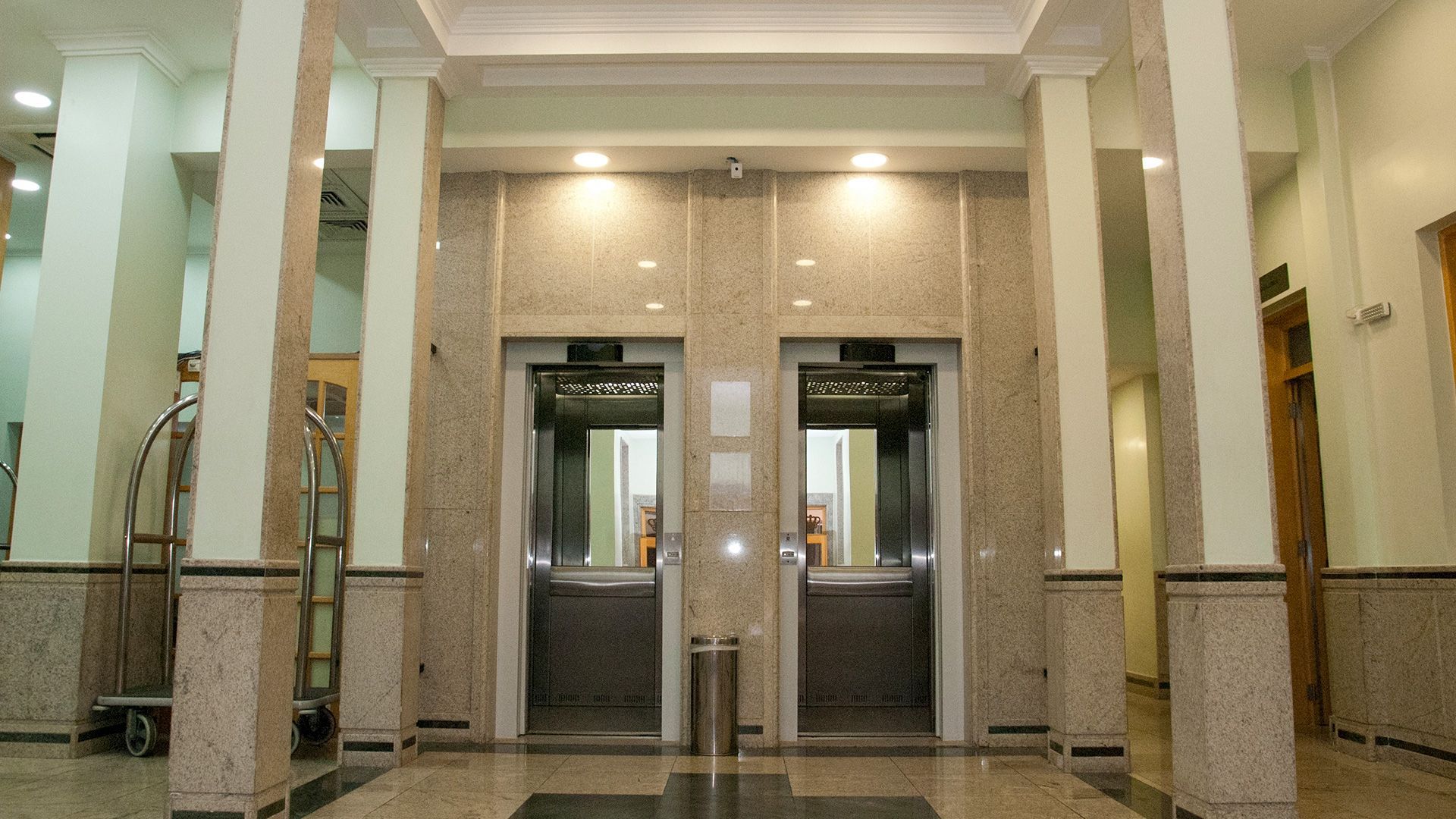 Há dois elevadores no saguão de um prédio.