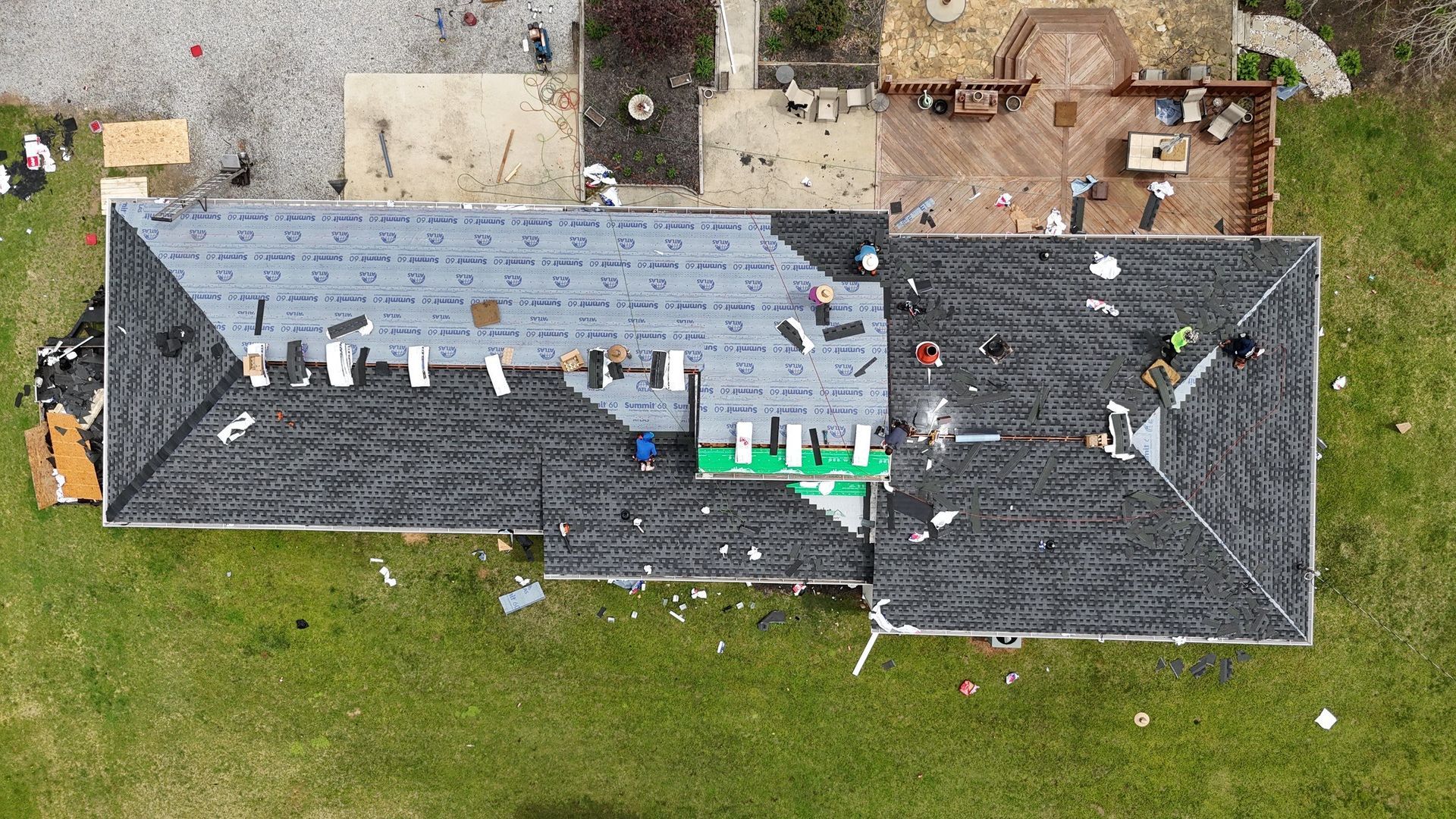 An aerial view of a house under construction with a roof being installed.