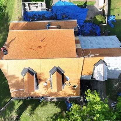 An aerial view of a house being remodeled with a new roof.
