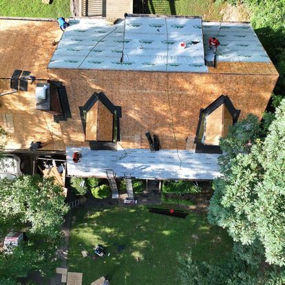 An aerial view of a house with a roof being installed.