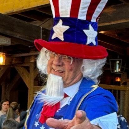 A man dressed as uncle sam is pointing at the camera.