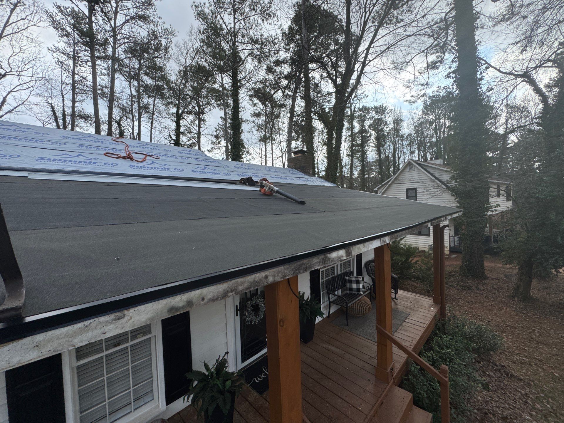 A roof is being installed on a house with a porch.