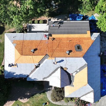 An aerial view of a house with a new roof being installed
