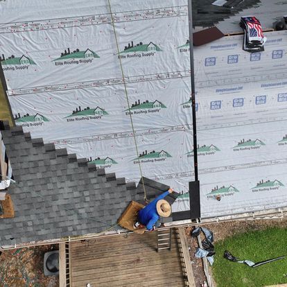 An aerial view of a roof being installed on a house.