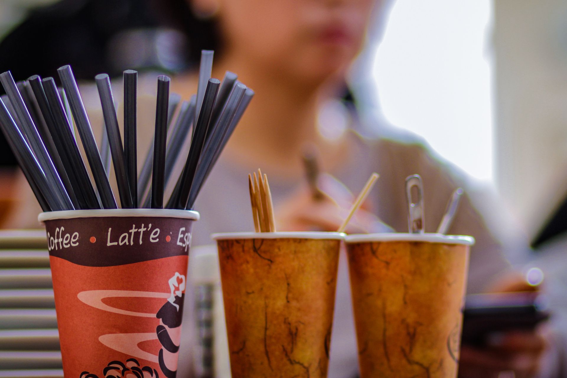 Close up shot of coffee straws, toothpicks in cups 