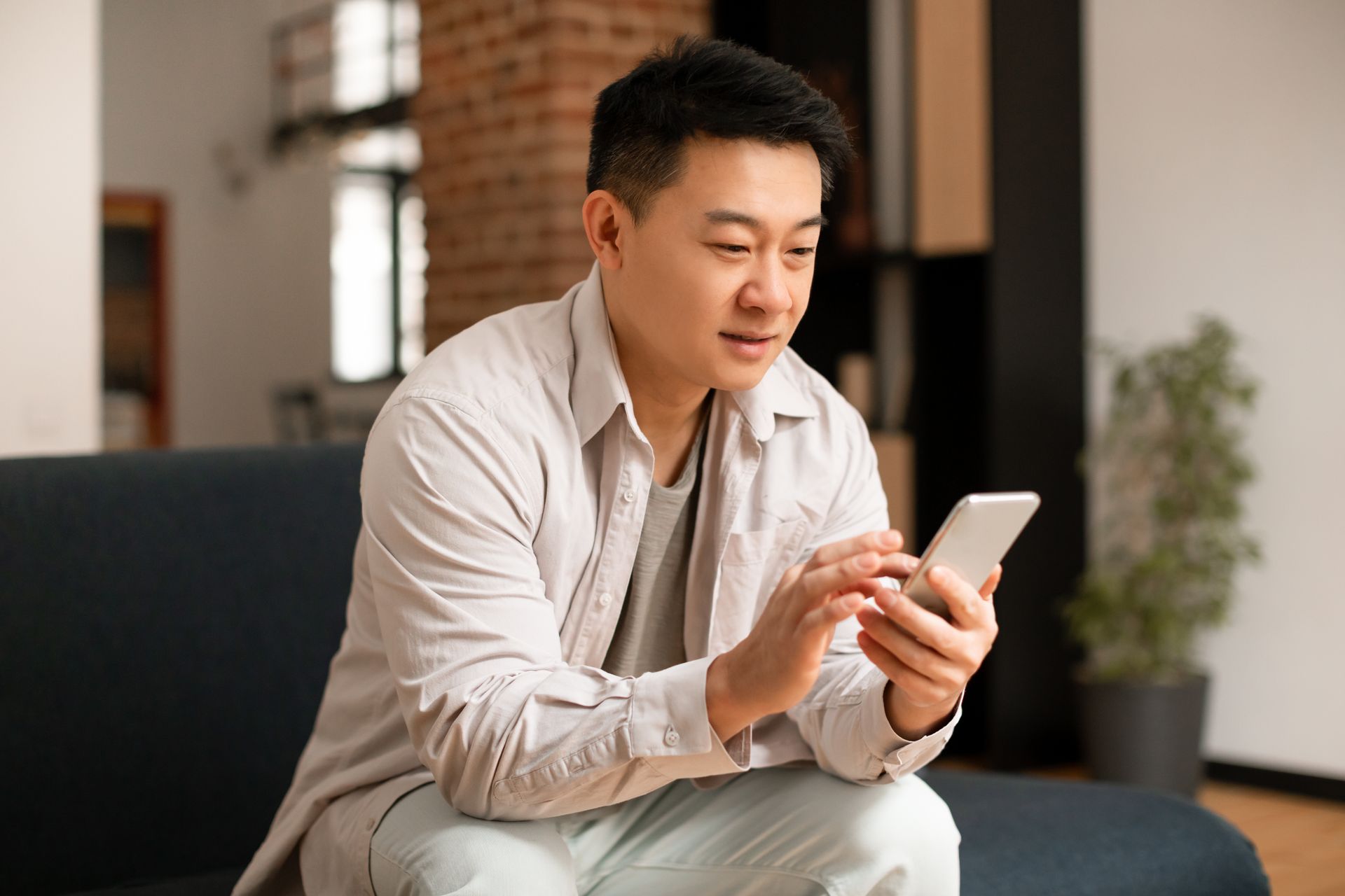 Asian guy reading Google reviews at his phone