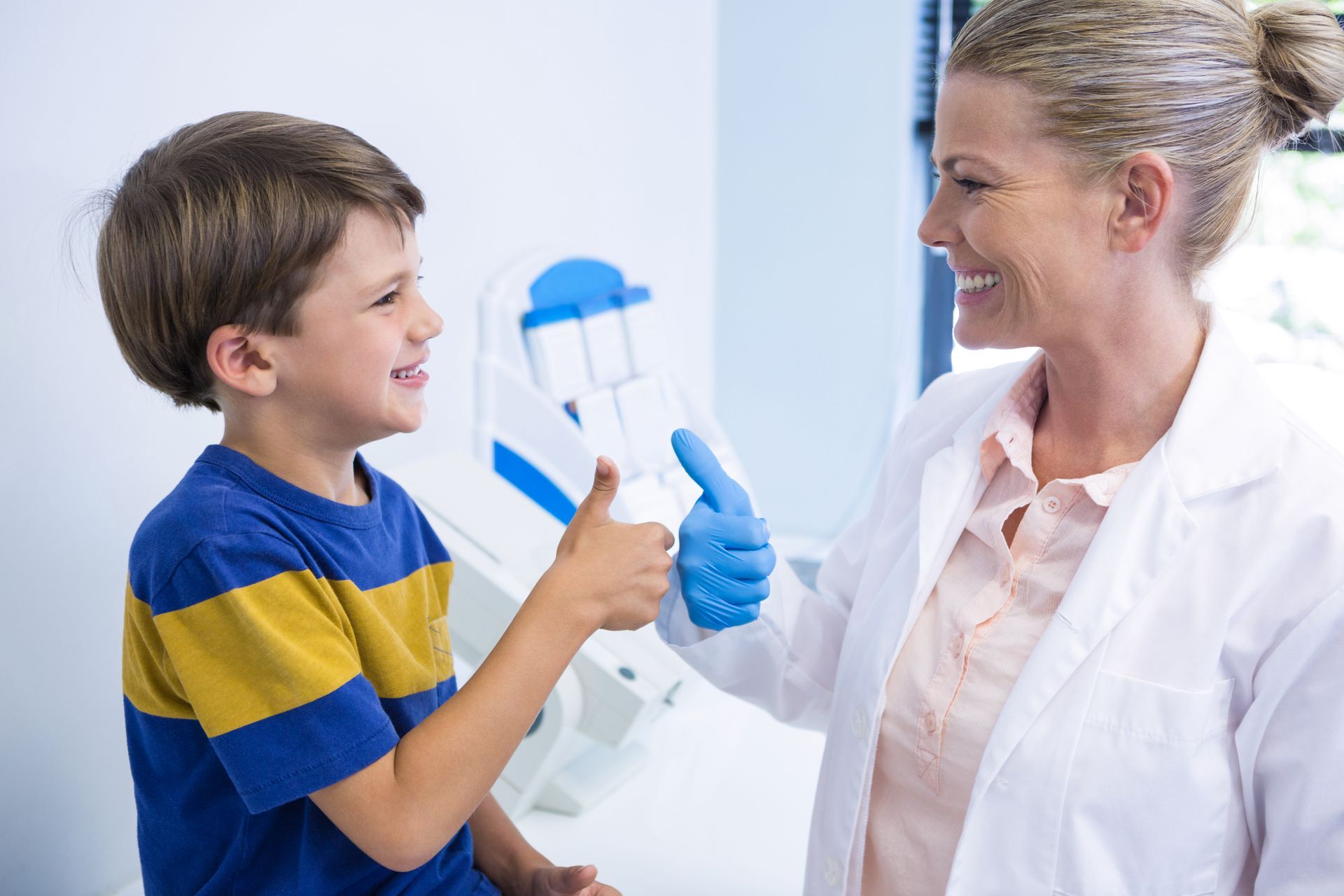 Female child dentist in Toowoomba and male toddler giving each other a thumbs up after a teeth cleaning