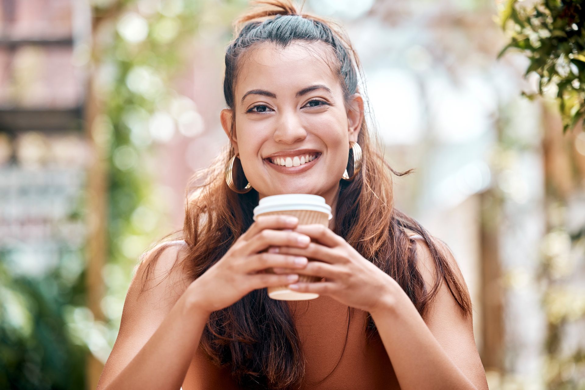 Mixed-races Aussie holding a cup of coffee in a coffee shop smiling