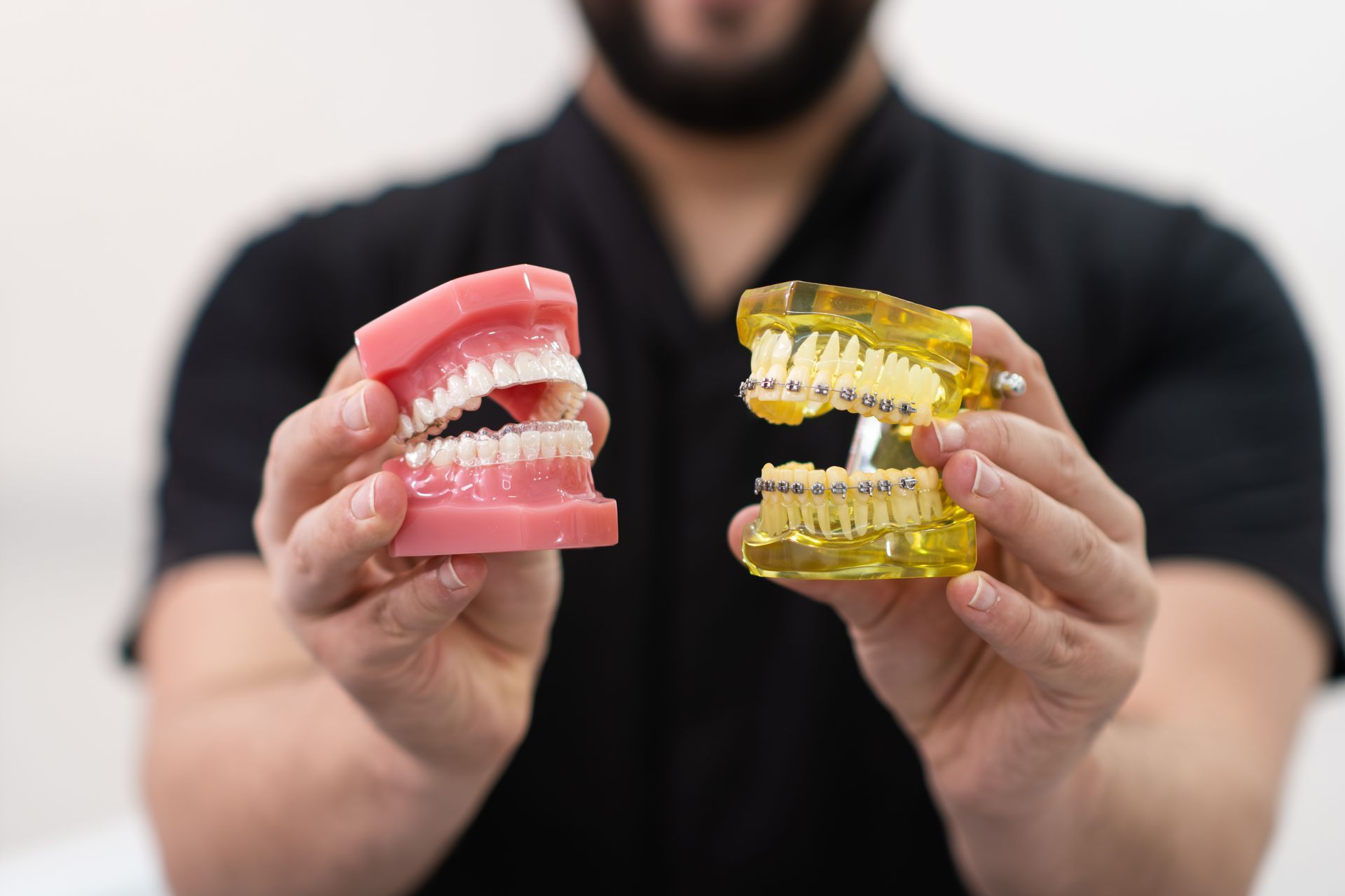 orthodontist performing metal dental braces and clear aligners differences